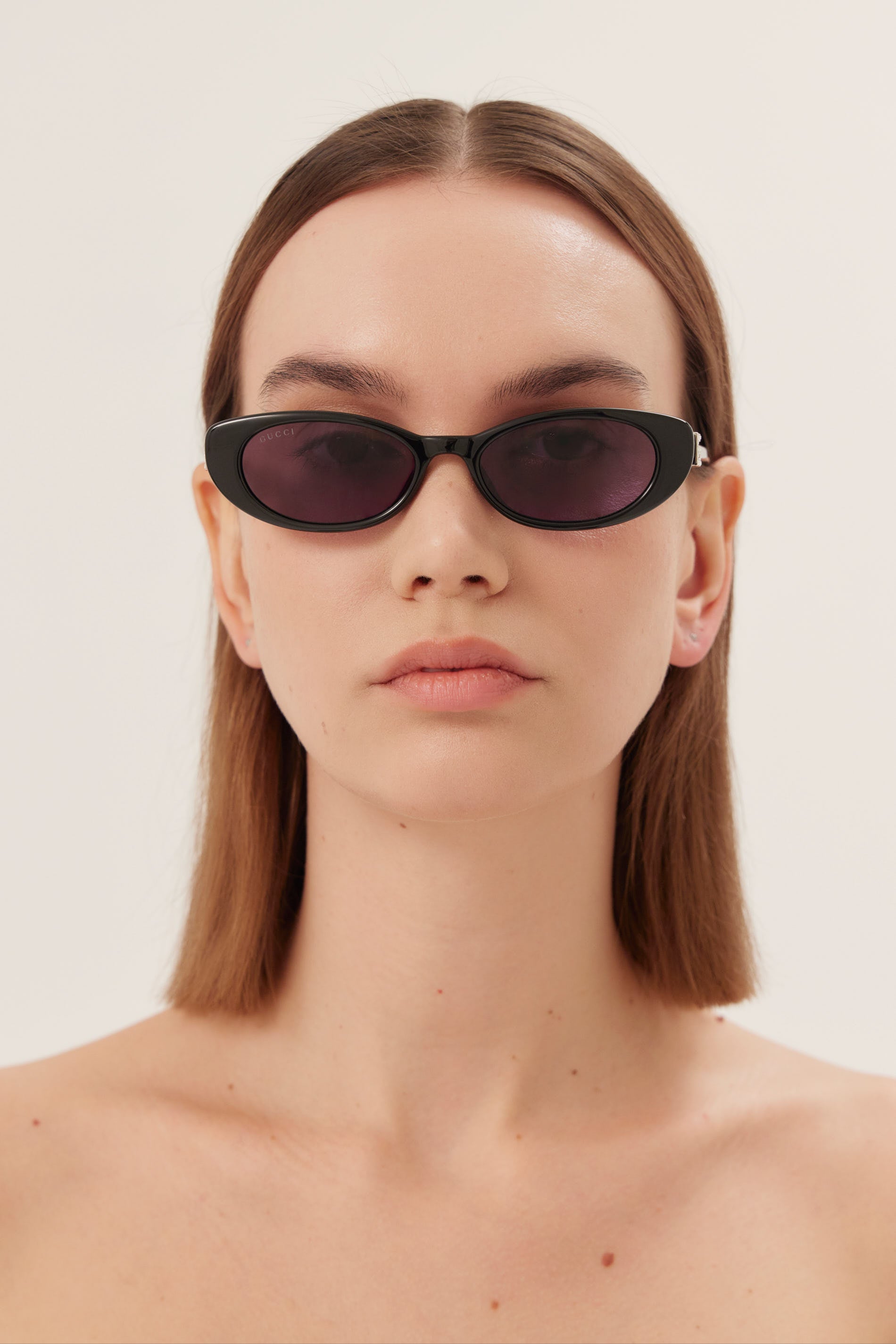 Oval cat-eye black Gucci sunglasses with bedded logo
