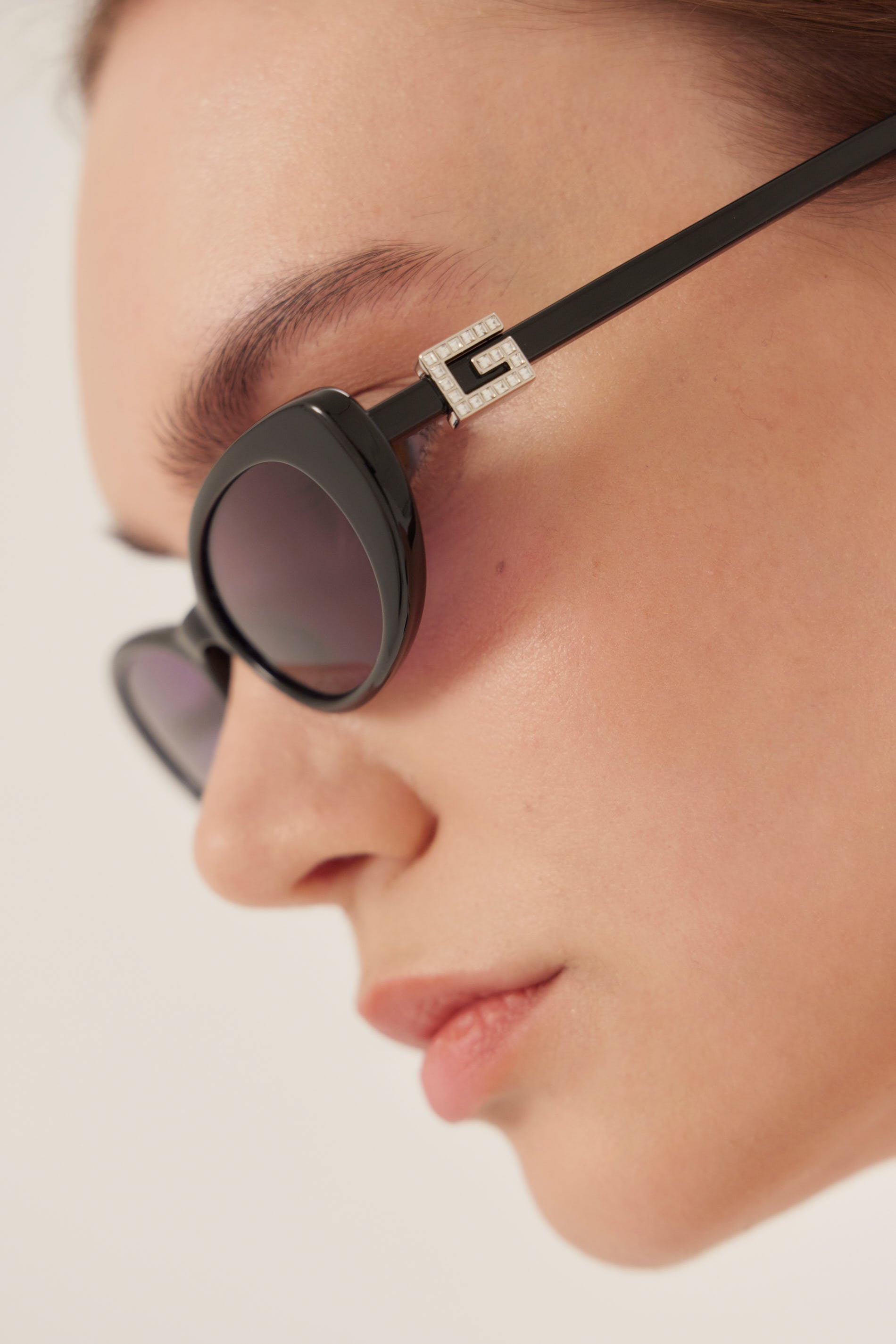Oval cat-eye black Gucci sunglasses with bedded logo